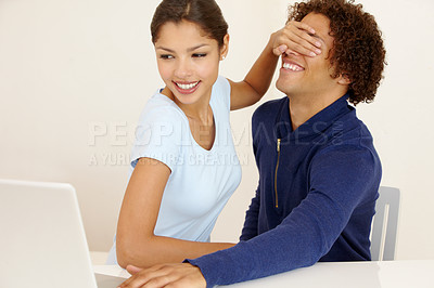 Buy stock photo Young woman covering her boyfriend&#039;s eyes so he can&#039;t see the laptop screen