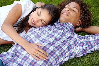 Buy stock photo Shot of a happy young couple napping together on the lawn