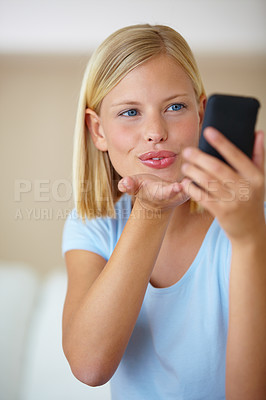 Buy stock photo Blow kiss, smartphone and video call with woman, social media and influencer live streaming in a lounge. Home, person or girl with cellphone, online followers and internet with post, app or happiness