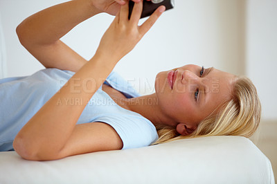 Buy stock photo Happy, cellphone or woman on a  couch, smile or typing with internet, social media or website info. Person on a sofa, apartment or girl with a smartphone, chatting or texting with digital app or home