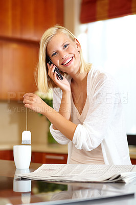 Buy stock photo Woman, smile and phone call in kitchen, communication and newspaper or information at home. Female person, smartphone and conversation or chat, tea and hot drink for breaking news or laugh for joke