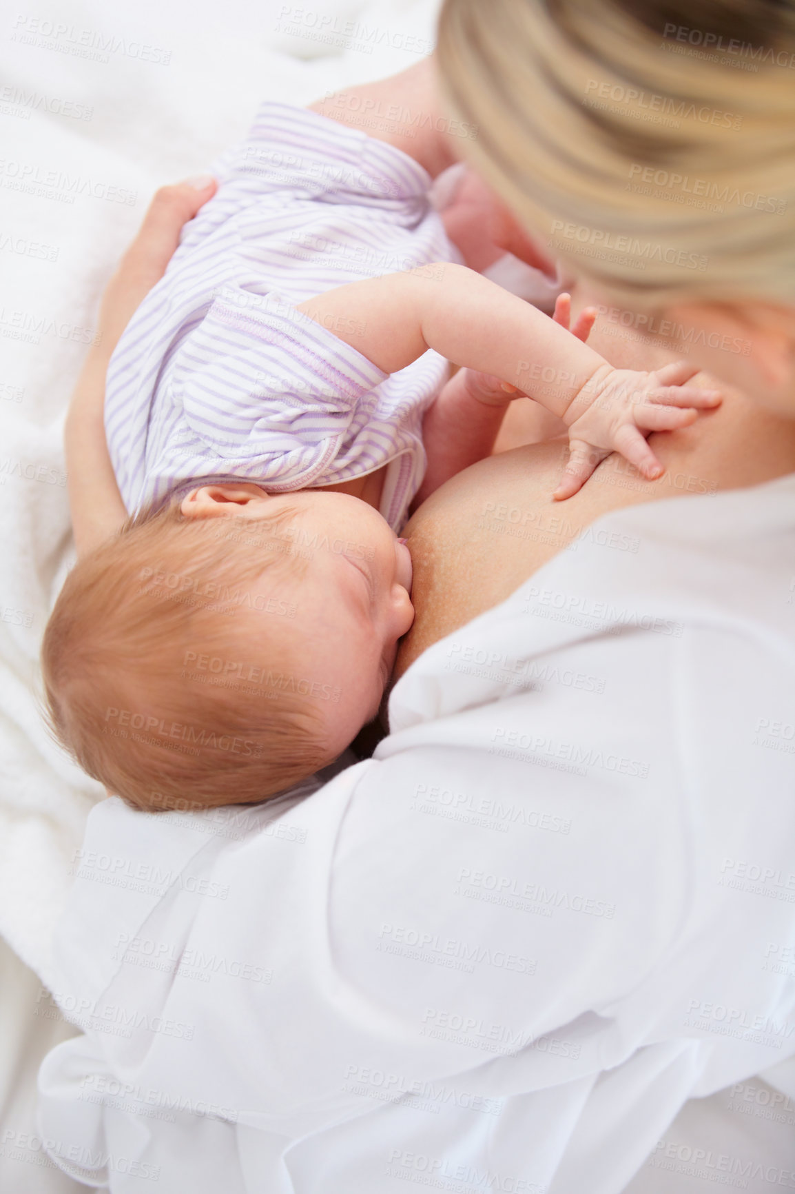 Buy stock photo High angle shot of a mother breastfeeding her newborn baby