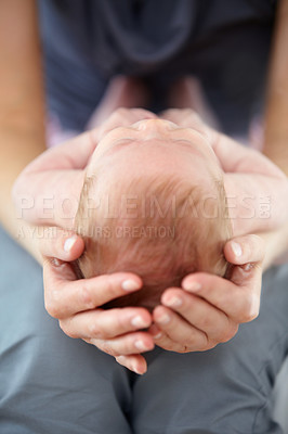 Buy stock photo Closeup cropped shot of a mother cradling her baby on her lap
