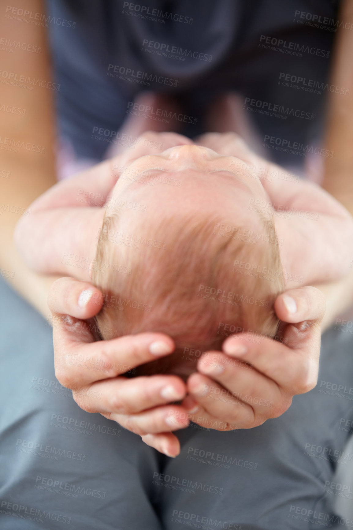 Buy stock photo Closeup cropped shot of a mother cradling her baby on her lap
