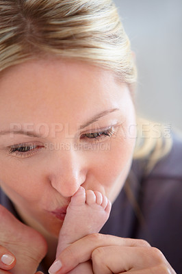 Buy stock photo Closeup shot of a mother tenderly kissing her newborn baby's tiny feet