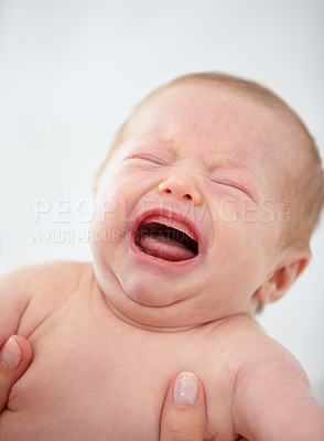 Buy stock photo Closeup, baby and crying for upset in home for pain, unhappy or sadness with mother. Woman, hand and holding of infant for bath time, diaper or change in nursery for hygiene, health or cleanliness