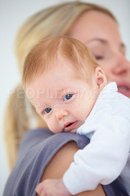 Buy stock photo Shot of a mother tenderly cradling her newborn ion her shoulder
