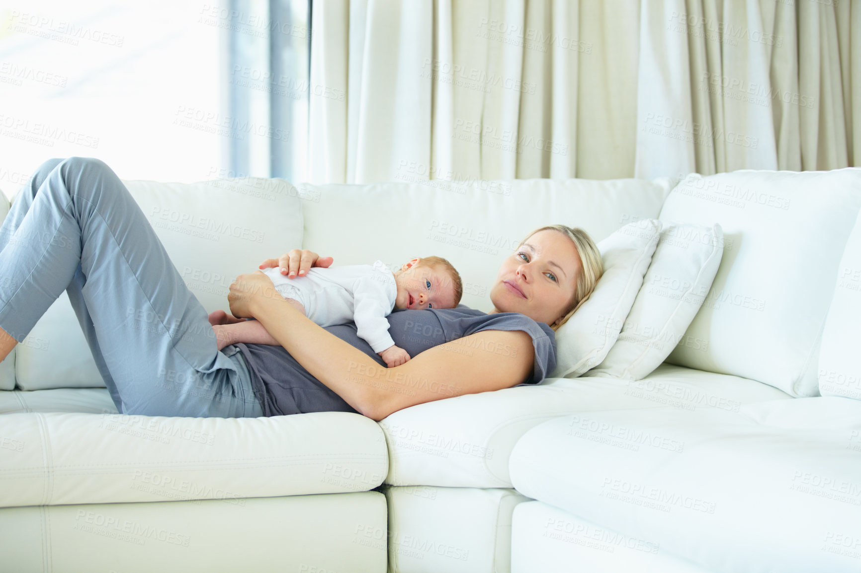 Buy stock photo Relax, home and sofa, mother and baby bonding, woman and kid lying in living room together. Calm morning, mom and newborn on couch for rest, love and family security, comfort and child care in lounge