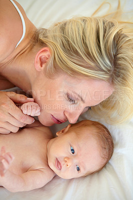 Buy stock photo Relax, love and bed, mother and baby bonding, woman and kid lying in home together. Calm morning, mom and newborn in bedroom for rest, kiss and family wellness, comfort and child care from above.