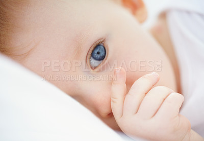 Buy stock photo Home, relax and face of baby in bed, resting and calm in nursery or wake up in morning. Family, blue eyes and closeup of young, infant newborn in bedroom for child development, health and wellness