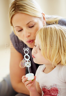 Buy stock photo Blowing, bubbles and games with mom and child together in home playing with toys for fun. Playful, mother and daughter with liquid, soap and bonding on holiday, vacation or relax on weekend with love