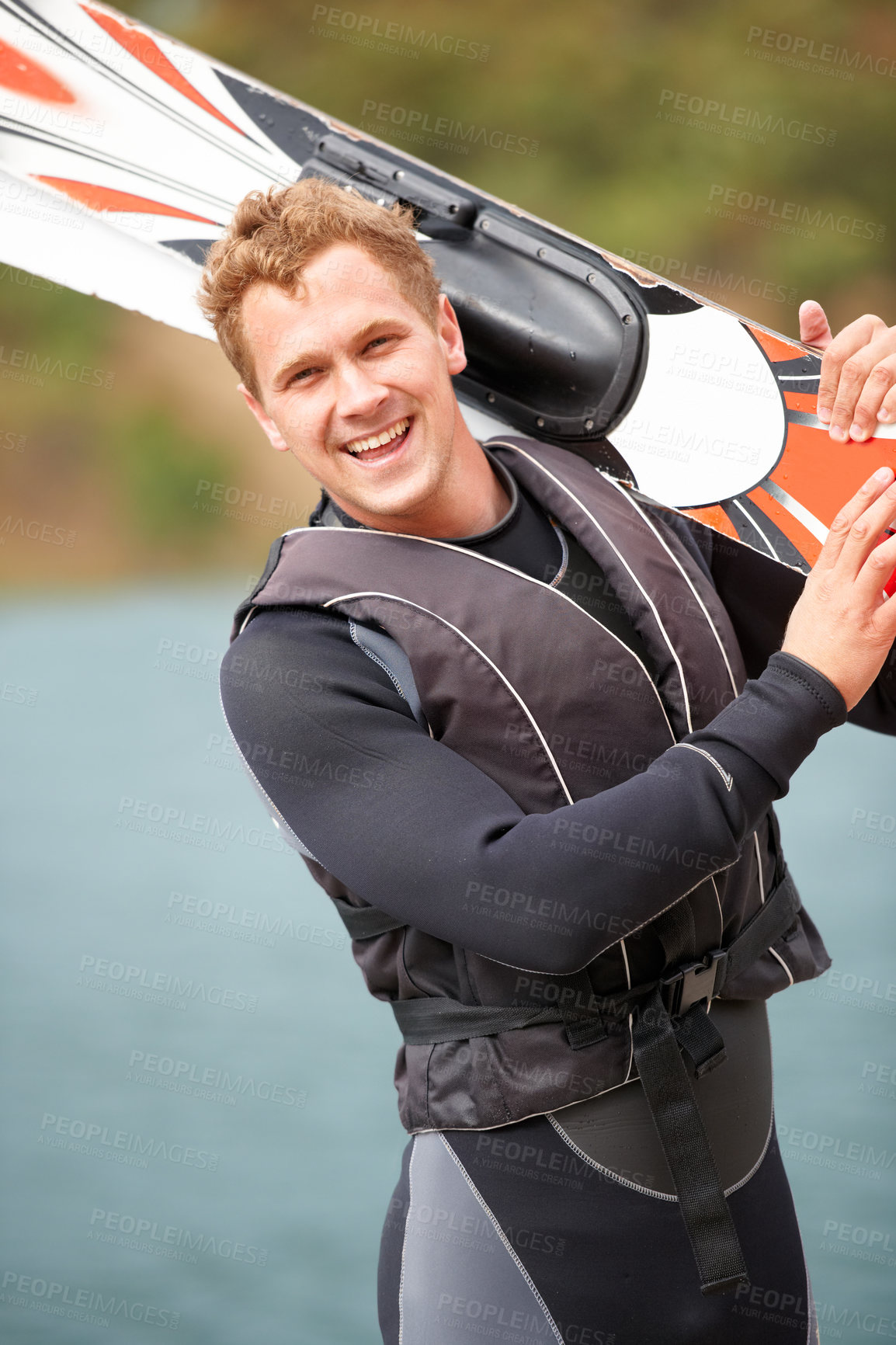 Buy stock photo Sports, portrait and man by water with wakeboard for surfing, exercise and recreation hobby by lake. Fitness, extreme sport and excited person with skiing board for freedom, adventure and outdoor fun