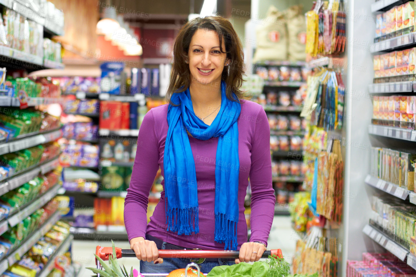 Buy stock photo A woman pushing her shopping cart in a grocery store