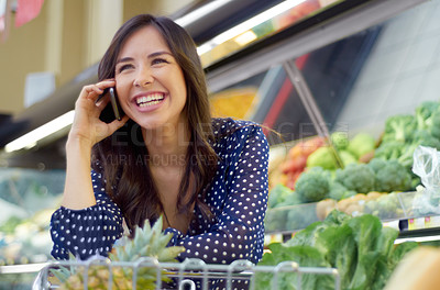 Buy stock photo A young woman on the phone in a grocery store