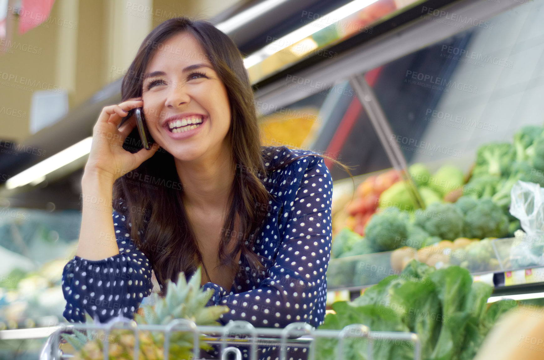 Buy stock photo A young woman on the phone in a grocery store