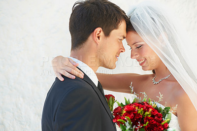 Buy stock photo A newlywed couple embracing one another on their wedding day