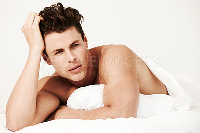 Buy stock photo A handsome male lying in his bed with no shirt on and looking at the camera