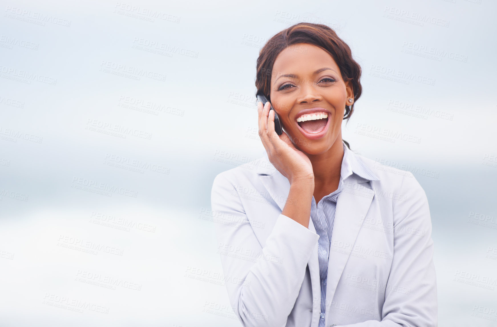 Buy stock photo A pretty african american woman having an enjoyable conversation while outdoors