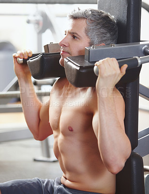 Buy stock photo A mature man working out on equipment at the gym