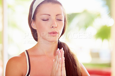 Buy stock photo A gorgeous young woman meditating during a yoga routine