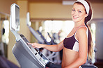 A fit young woman using the treadmill at gym