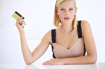 Buy stock photo Gorgeous young woman sitting and holding a credit card - portrait