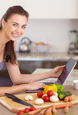 Buy stock photo Portrait of a beautiful young woman looking for recipes on her digital tablet while cooking