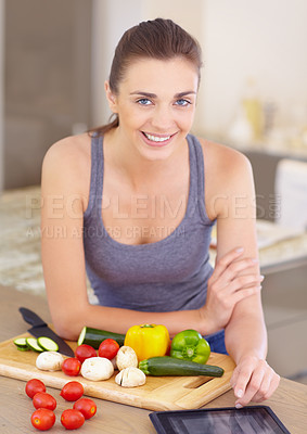 Buy stock photo Portrait of an attractive young woman looking for recipes online while cooking