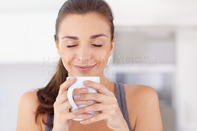 Buy stock photo An attractive young woman taking in the aroma of her coffee