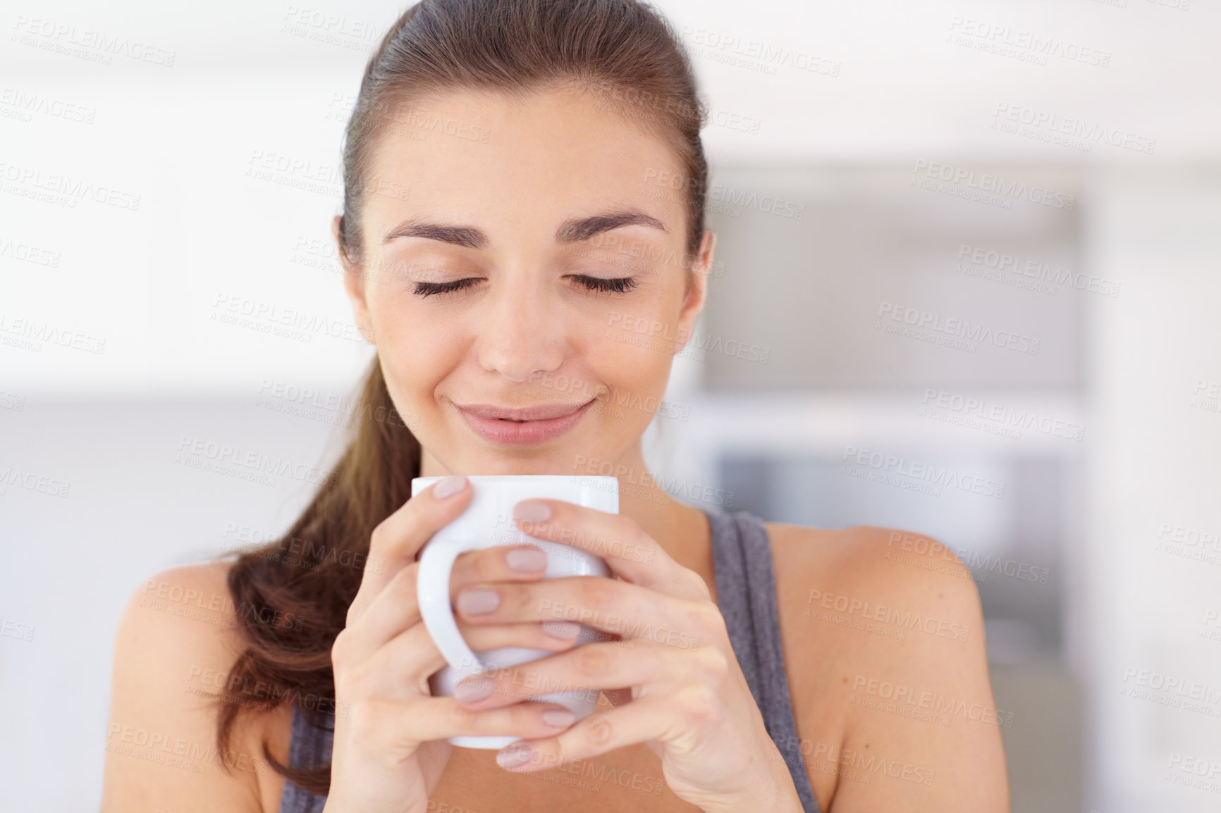 Buy stock photo An attractive young woman taking in the aroma of her coffee