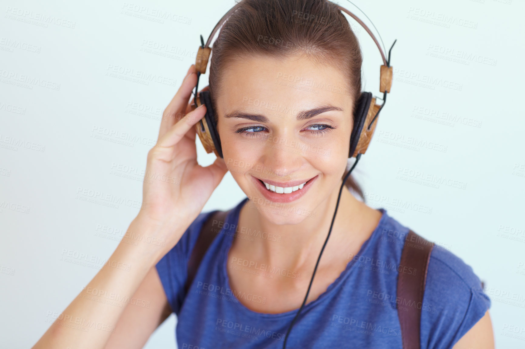 Buy stock photo An attractive young woman listening to music through her headphones
