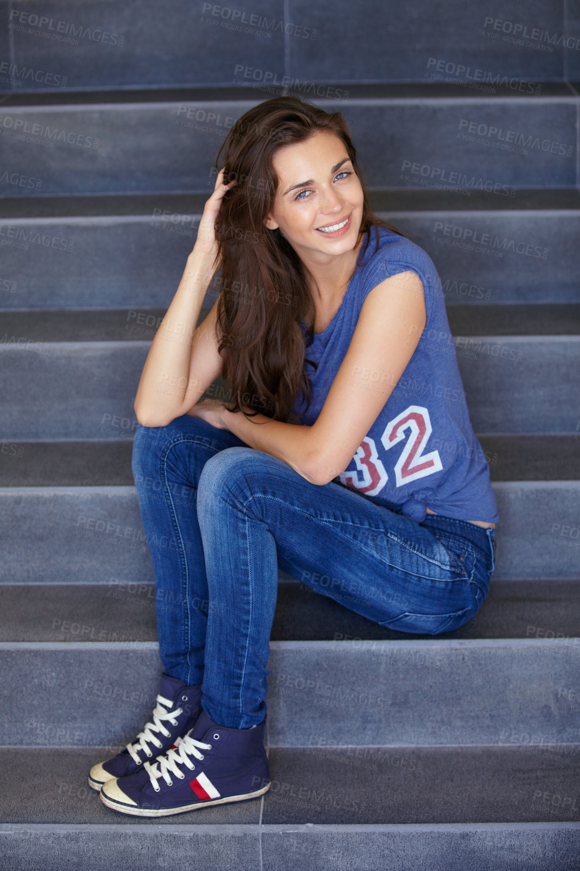 Buy stock photo Portrait of a happy young woman sitting on some steps