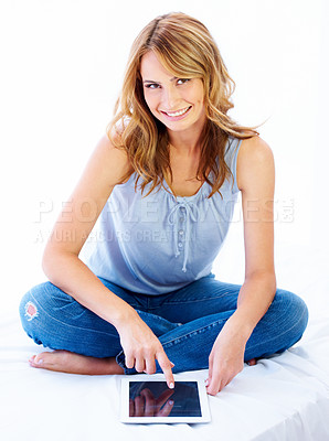 Buy stock photo Portrait, tablet and a woman sitting on her bed in studio isolated against a white background for social media browsing. Bedroom, technology or research with a happy young female user on the internet
