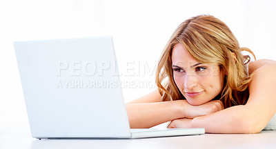 Buy stock photo An attractive young woman lying on the floor and waiting next to her laptop