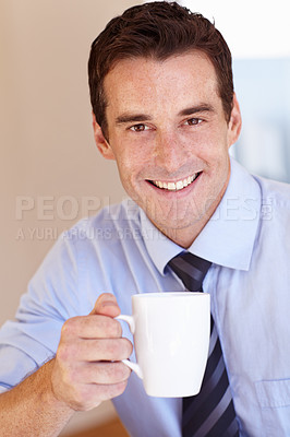 Buy stock photo Smiling young businessman enjoying his coffee break