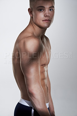 Buy stock photo Young man flexing his muscles and looking at the camera