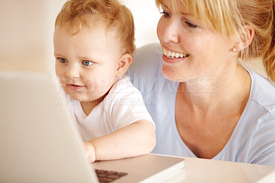 Buy stock photo Happy, mother and baby on laptop for remote work in the living room at home for professional career. Smile, woman and little infant child while browsing online on a computer for freelance research 