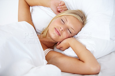 Buy stock photo Young woman lying on her bed with her arms outstretched and her eyes closed