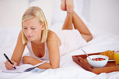 Buy stock photo Woman, bed and notebook with breakfast, thinking and writing in diary, plan and bedroom for journaling. Food, fruits and croissant with orange juice, nutrition or healthy diet in home, rest or happy