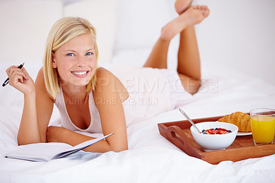 Buy stock photo Woman, bed and notebook with breakfast, portrait and happy with smile, bedroom for journaling. Food, fruits and croissant with orange juice, nutrition and healthy diet in home, rest and cheerful