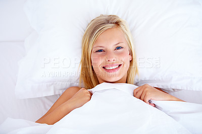 Buy stock photo Gorgeous young woman lying in bed smiling up at the camera - portrait