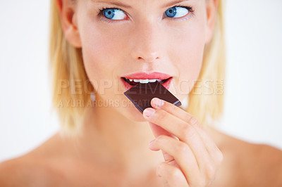Buy stock photo Young woman enjoying a delicious piece of chocolate