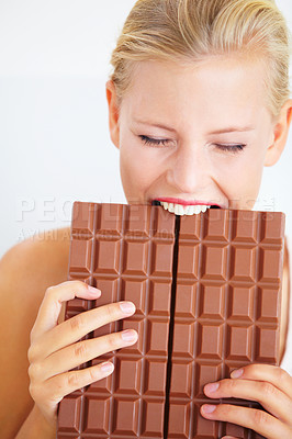 Buy stock photo Eating woman, hungry and bite chocolate bar, delicious snack or candy for studio food, dessert or sugar craving. Diet cheat meal calories, diabetes or girl hunger for cacao sweets on white background