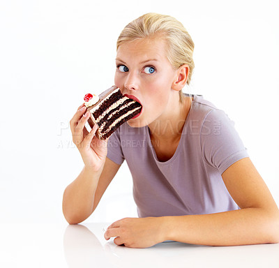 Buy stock photo Young woman stuffing her mouth full of chocolate cake