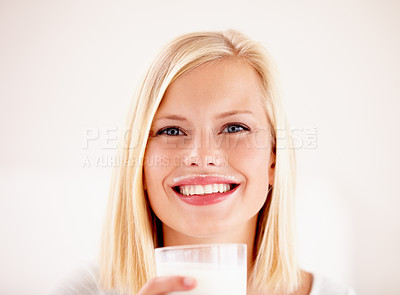 Buy stock photo Portrait, milk mustache and a woman drinking from a glass in studio isolated on a white background. Happy, nutrition and calcium with a health young female enjoying a drink for vitamins or minerals