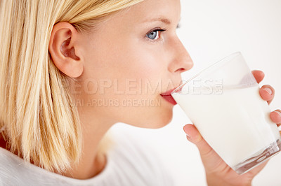 Buy stock photo Face, milk and thinking with a woman drinking from a glass in studio isolated on a white background. Idea, nutrition and calcium with a healthy young female enjoying a drink for natural vitamins