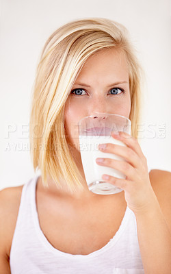 Buy stock photo Portrait, milk and a woman drinking from a glass in studio isolated on a white background. Health, nutrition and calcium with a young female enjoying a drink for natural vitamins in the morning