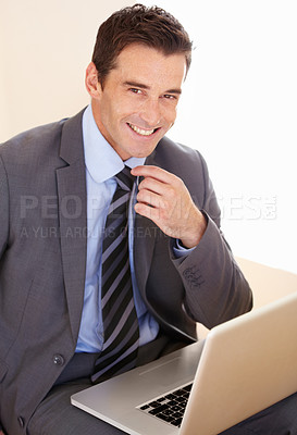 Buy stock photo Portrait of a handsome young businessman using his laptop