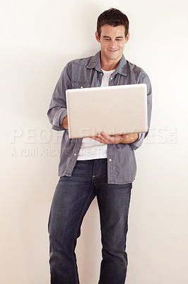 Buy stock photo A handsome young man working on his laptop
