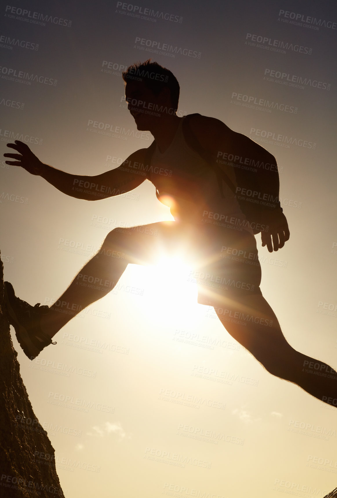 Buy stock photo A silhouette of a man jumping over rocks
